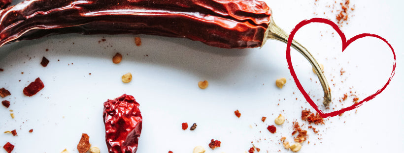 Un piment rouge avec des éclats d'épices illustré d'un coeur