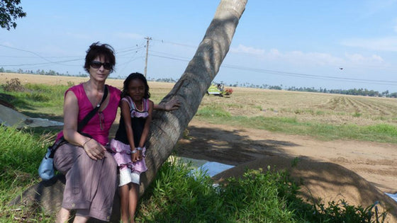 florence Dubus et une fillette kéralaise assisent sur un tronc d'arbre